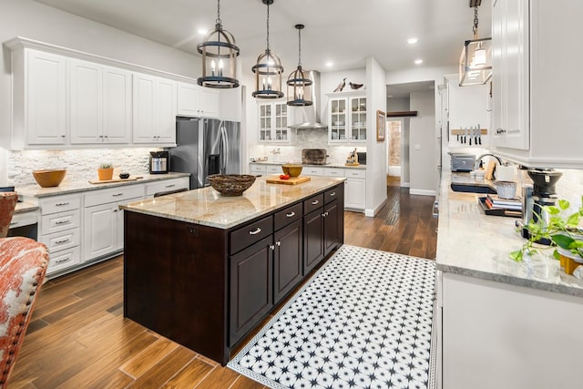 kitchen featuring dark hardwood / wood-style floors, a center island, sink, and stainless steel refrigerator with ice dispenser