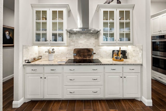 bar with white cabinets, dark hardwood / wood-style flooring, wall chimney range hood, and black electric cooktop