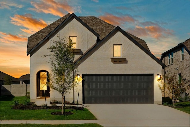 view of front of home with a garage and a lawn