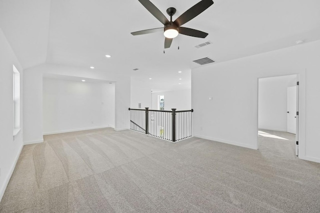 carpeted spare room featuring ceiling fan and lofted ceiling