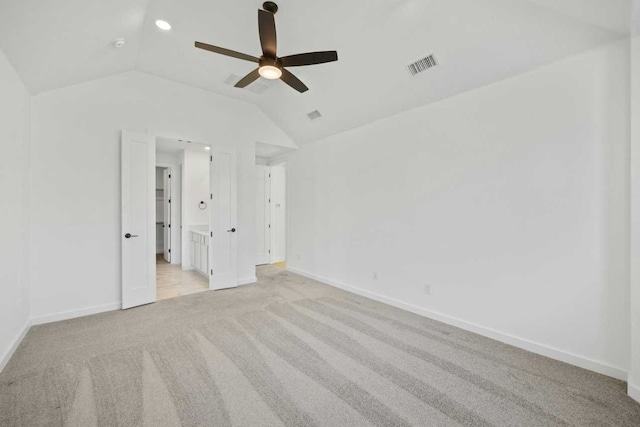 unfurnished bedroom with ceiling fan, lofted ceiling, and light carpet