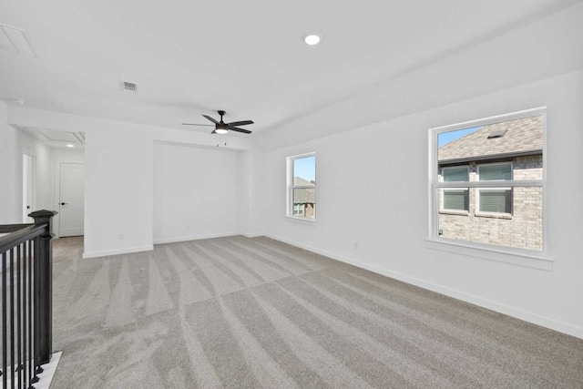 spare room with a wealth of natural light, ceiling fan, and light carpet