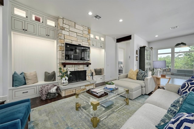 living room featuring a stone fireplace and hardwood / wood-style flooring