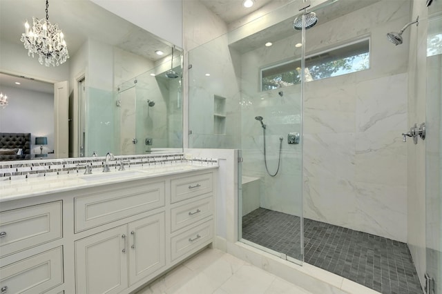 bathroom featuring a chandelier, vanity, and a shower with door