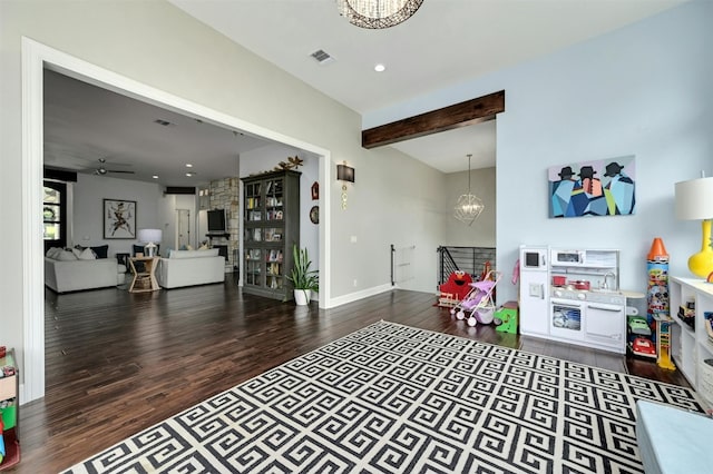 game room featuring wood-type flooring, beam ceiling, and ceiling fan with notable chandelier