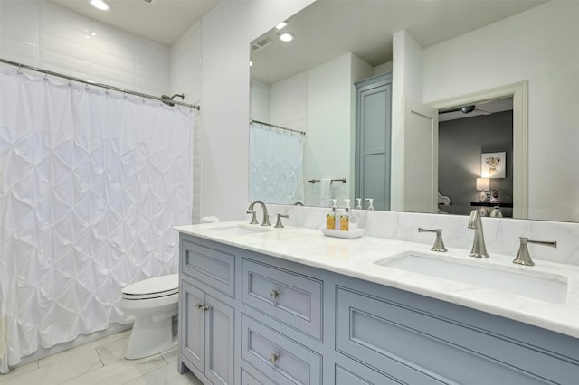 bathroom with curtained shower, vanity, and toilet