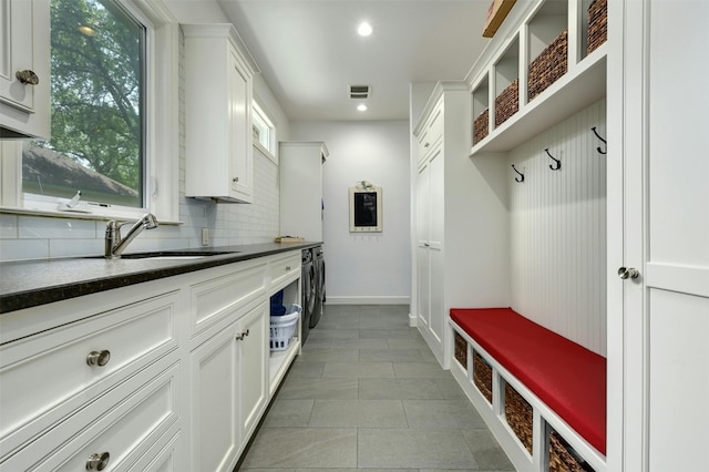 mudroom featuring light tile patterned floors, sink, and washing machine and clothes dryer