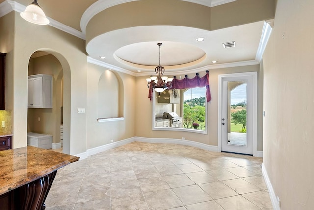 tiled dining space featuring a tray ceiling, crown molding, and a notable chandelier