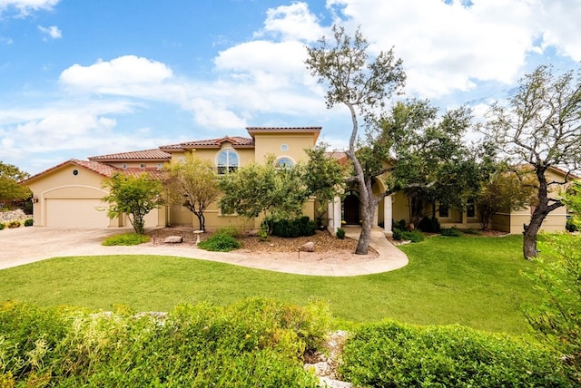 mediterranean / spanish house with a front lawn and a garage