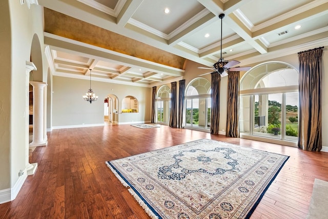 interior space featuring hardwood / wood-style flooring, plenty of natural light, crown molding, and decorative columns