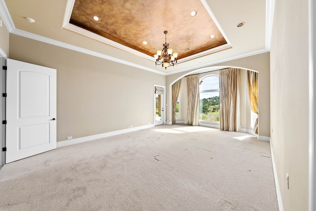 unfurnished room featuring a chandelier, carpet flooring, crown molding, and a raised ceiling