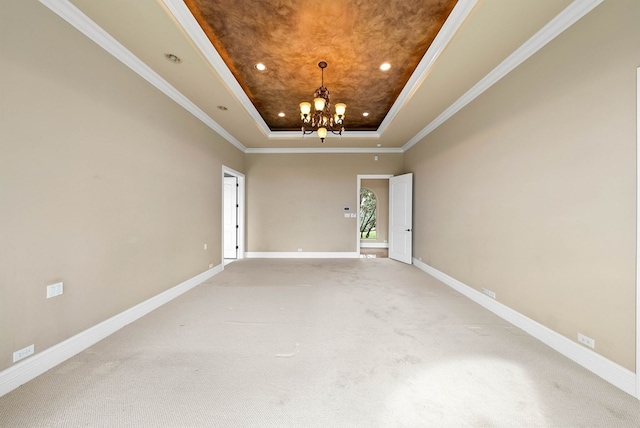 unfurnished room with a chandelier, crown molding, carpet, and a tray ceiling