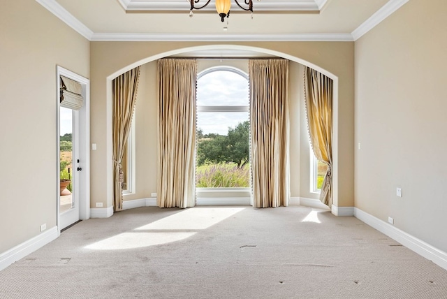 carpeted empty room featuring crown molding and a notable chandelier