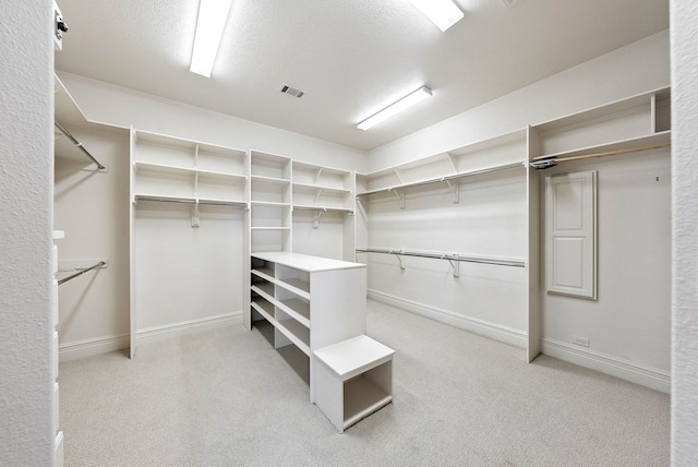 spacious closet with light colored carpet