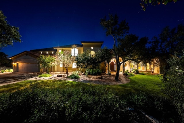 view of front of house with a garage and a lawn