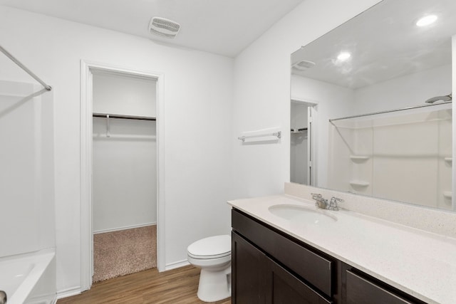 full bathroom featuring hardwood / wood-style floors, tub / shower combination, vanity, and toilet