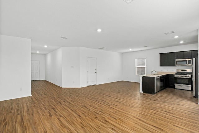 unfurnished living room with hardwood / wood-style floors and sink