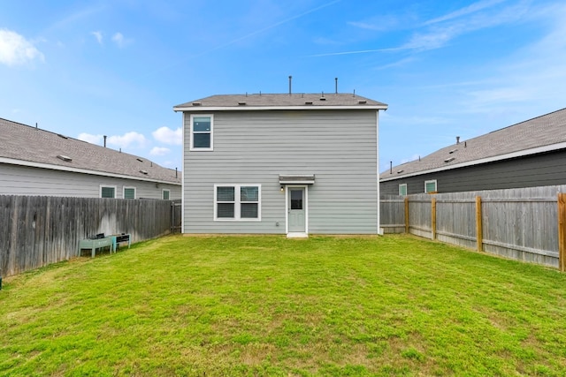 rear view of house featuring a yard