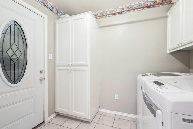 laundry room featuring cabinets, washer and clothes dryer, and light tile patterned flooring