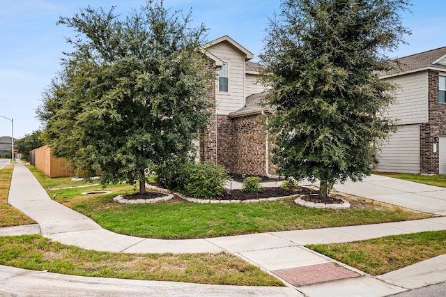 view of property hidden behind natural elements featuring a front yard