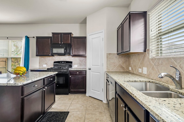 kitchen with dark brown cabinetry, black appliances, sink, and light stone counters