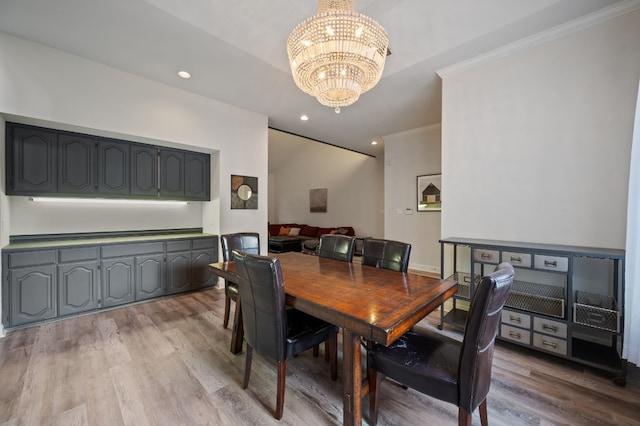 dining area with light hardwood / wood-style floors, a chandelier, and crown molding