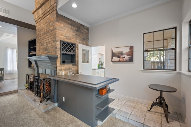 kitchen featuring ornamental molding, kitchen peninsula, light colored carpet, and sink