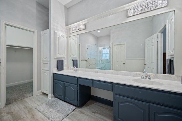 bathroom featuring hardwood / wood-style flooring, a shower with shower door, and vanity