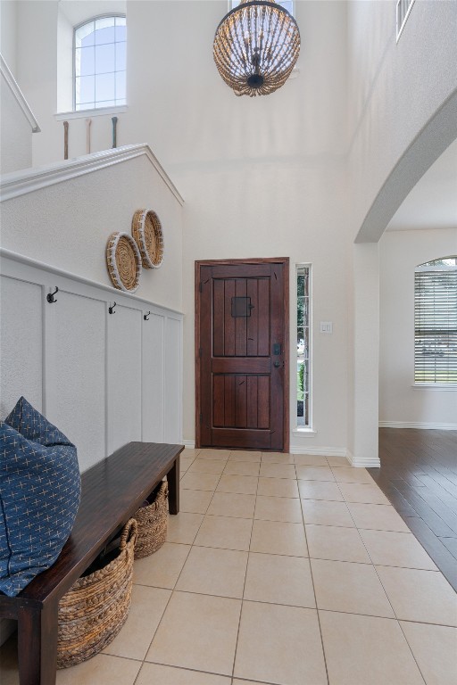 foyer entrance with a towering ceiling and light tile patterned floors