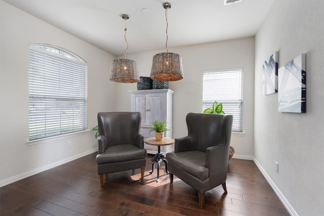 sitting room with dark wood-type flooring and a healthy amount of sunlight