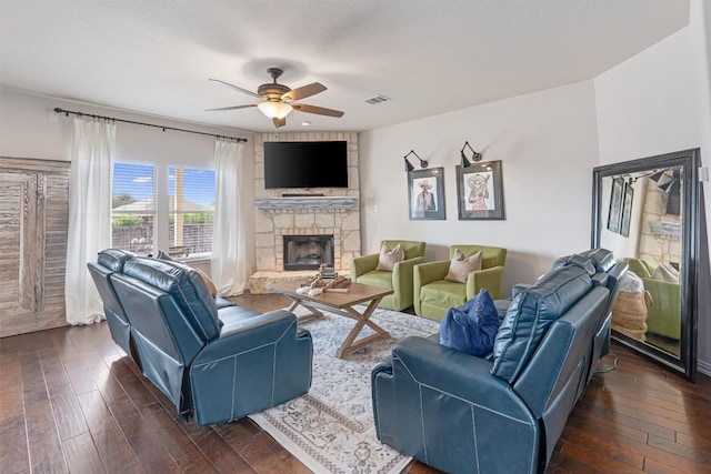 living room featuring a fireplace, ceiling fan, dark hardwood / wood-style flooring, and a textured ceiling