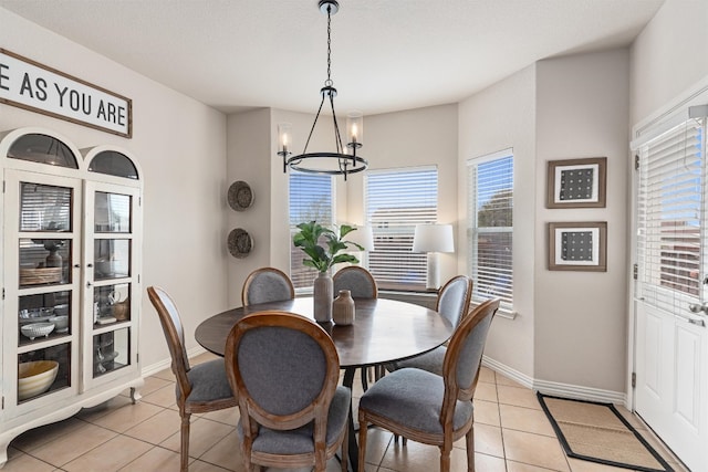 dining room featuring light tile patterned floors, a textured ceiling, and a notable chandelier