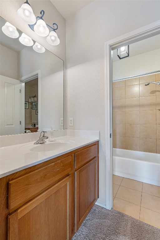 bathroom with tile patterned flooring, vanity, and tiled shower / bath