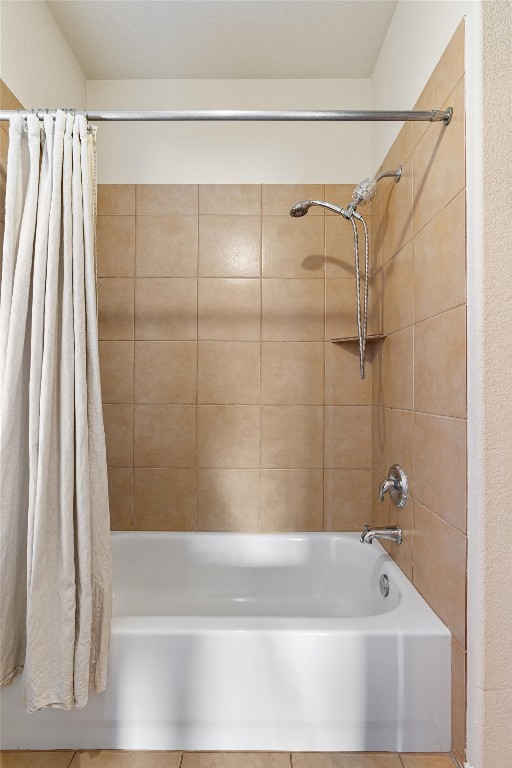 bathroom with tile patterned floors and shower / bathtub combination with curtain