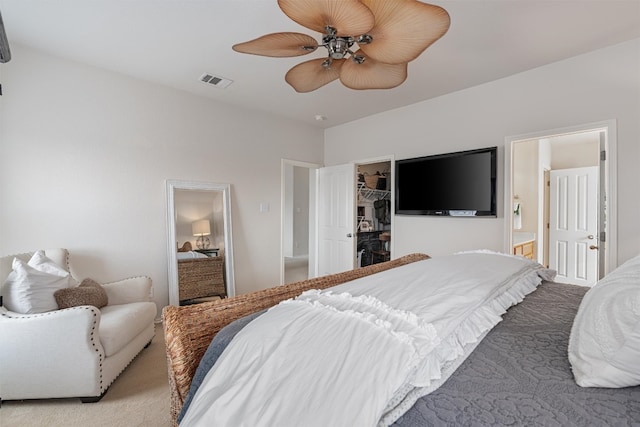 bedroom featuring ensuite bathroom, light colored carpet, ceiling fan, a spacious closet, and a closet