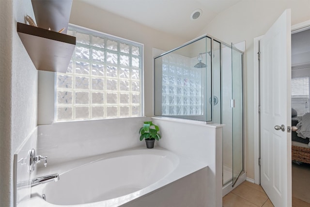 bathroom featuring a wealth of natural light, tile patterned flooring, and independent shower and bath