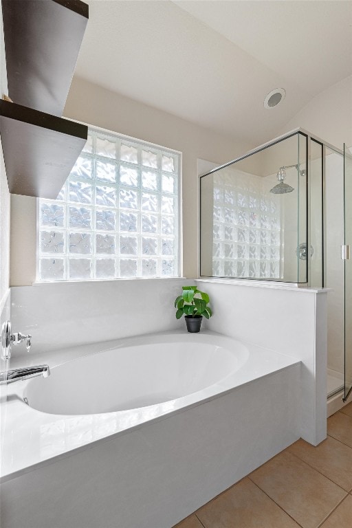 bathroom with tile patterned floors and shower with separate bathtub