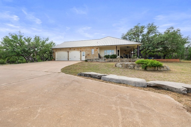 view of front of house featuring a garage, covered porch, and a front yard