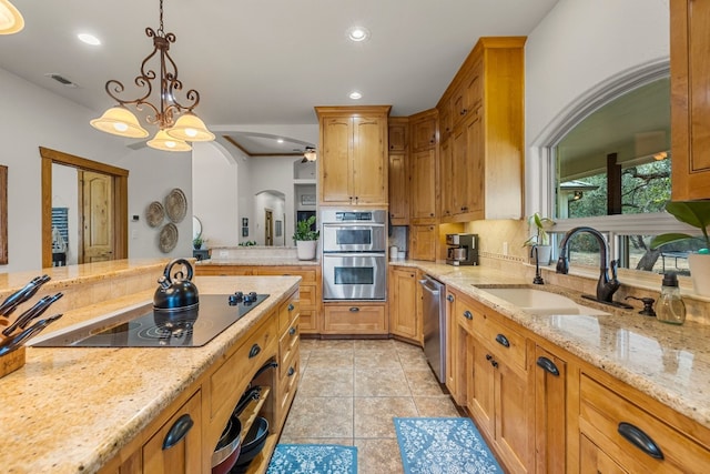 kitchen with pendant lighting, sink, light tile patterned floors, light stone counters, and stainless steel appliances