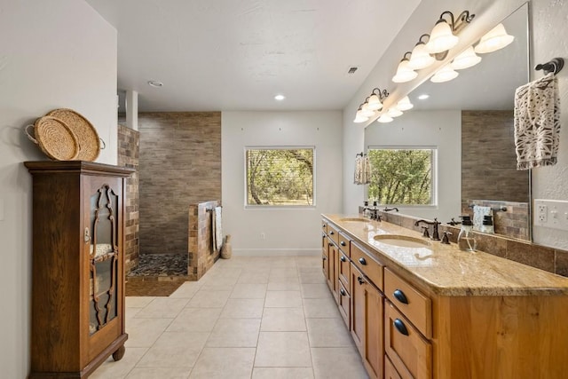 bathroom featuring vanity, tile patterned flooring, and a tile shower