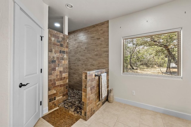 bathroom featuring a healthy amount of sunlight, tile patterned flooring, and tiled shower