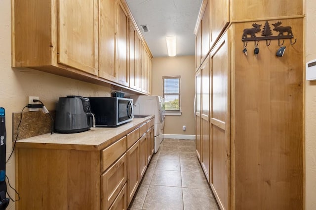 kitchen featuring light tile patterned flooring and light brown cabinetry