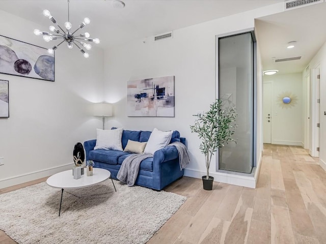 living room featuring a chandelier and light wood-type flooring