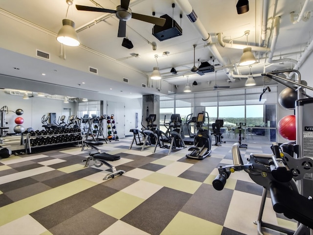 exercise room with ceiling fan and a high ceiling