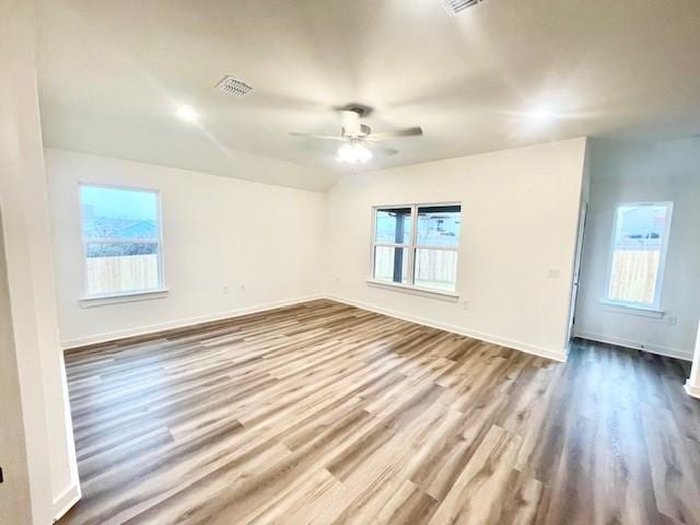 spare room featuring lofted ceiling, light hardwood / wood-style floors, and ceiling fan