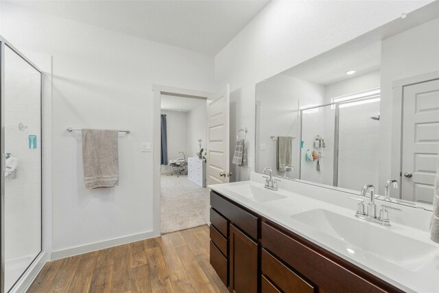 bathroom featuring wood-type flooring, vanity, and a shower with shower door