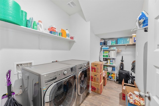 laundry room with light hardwood / wood-style flooring and washer and clothes dryer