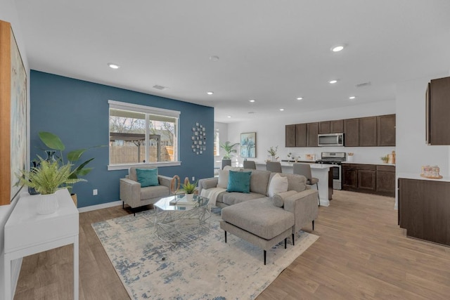 living area with recessed lighting, light wood-style floors, visible vents, and baseboards