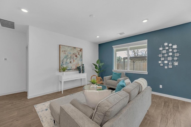 living room featuring recessed lighting, wood finished floors, visible vents, and baseboards