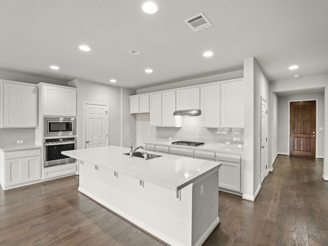 kitchen featuring dark wood-type flooring, appliances with stainless steel finishes, and white cabinets